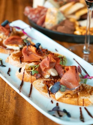 Tuscan Fig & Cheese Crostini arranged on a white platter