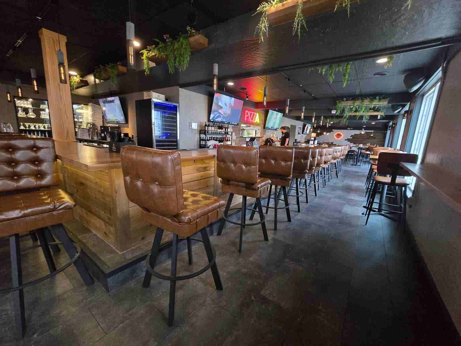 The long bar, stools and screens inside Crust & Cocktails in Liberty Commons, Akron